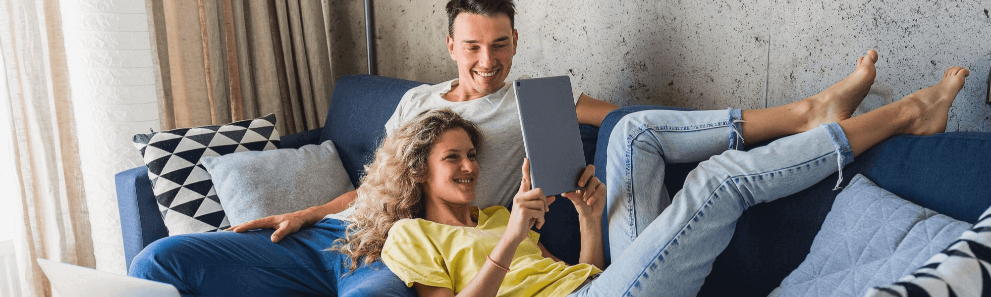 couple sitting on couch watching their tablet