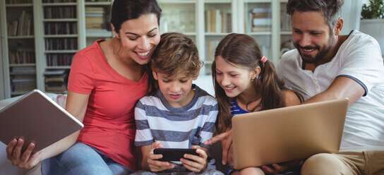 family on their electronics on the couch