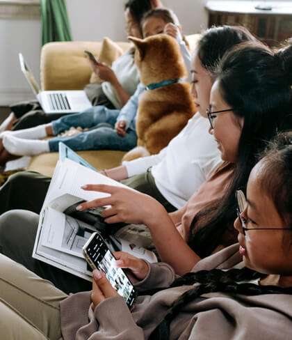 Asian family lounge together with their own mobile devices