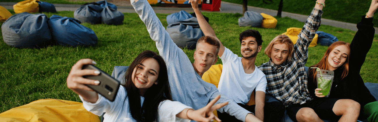 Teenagers taking a picture with a cell phone in the park