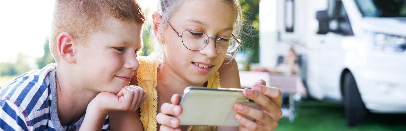 Kids camping use mobile phone outdoors